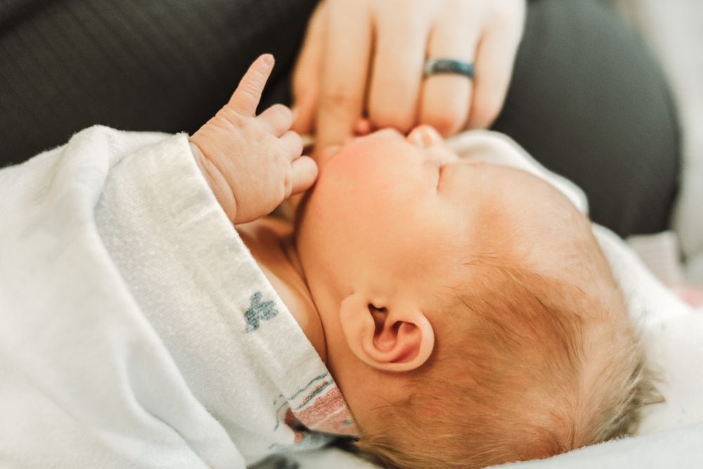 Newborn with mom in Fresh 48, little fingers up