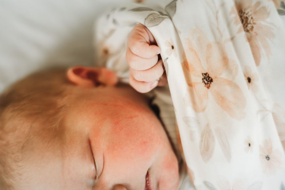 Newboarn closeup portrait, swaddled hands up