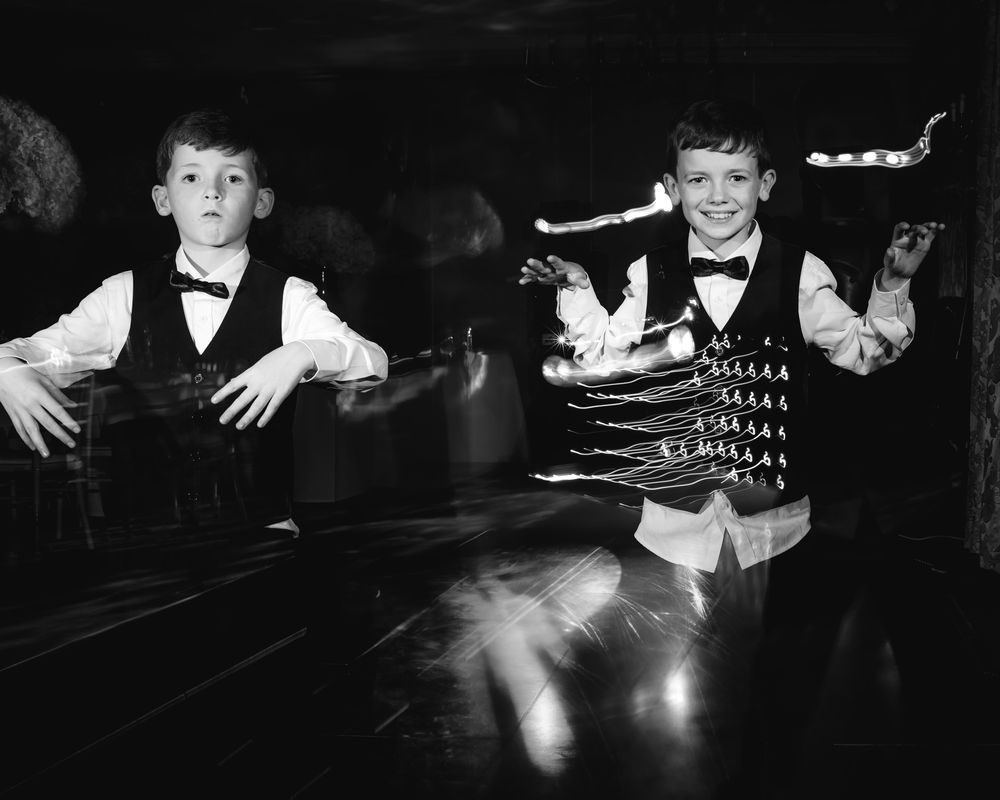 A series of black and white vintage photographs showing children playing at a table in low light conditions.