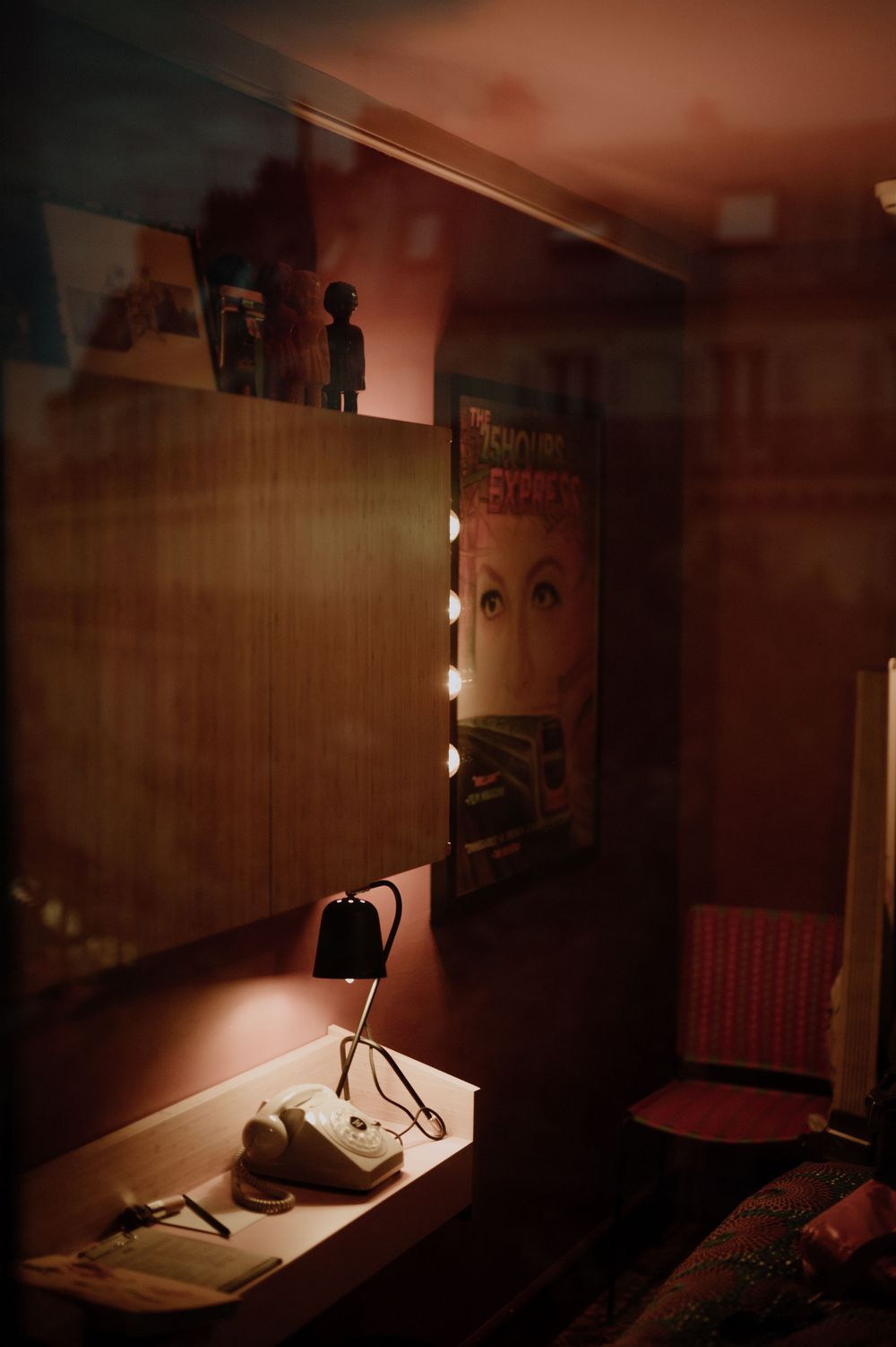 Warm-toned interior room with theatrical lighting and vintage decor elements.
