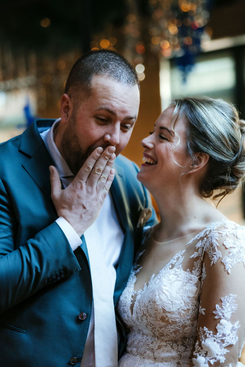 A happy candid moment between newlyweds sharing laughter during their wedding celebration.