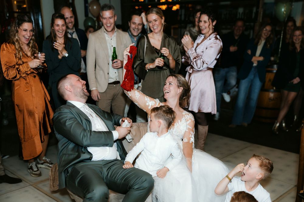 A lively wedding reception moment shows dancers enjoying themselves on the dance floor as guests watch and celebrate.