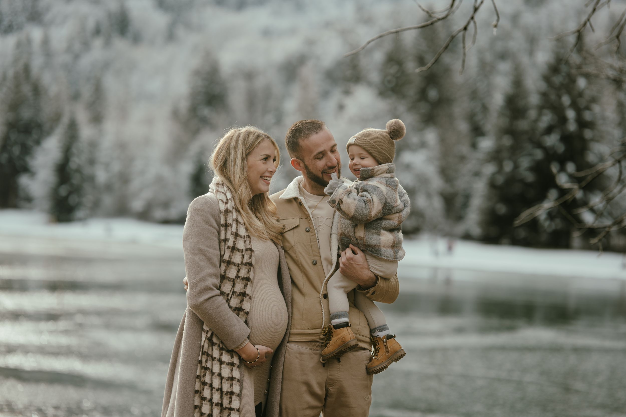 Happy family shares tender moment in winter mountain setting.