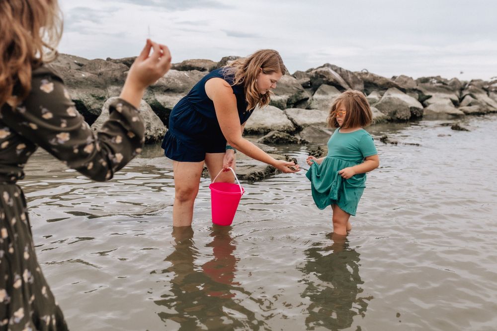 mom playing in the water at the beach with her girls in norfolk, virginia