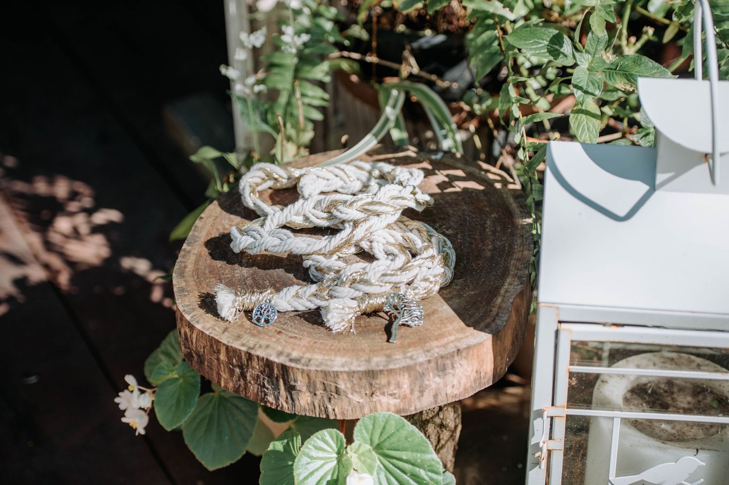 Wedding cookies displayed on a rustic wood slice platter with greenery decoration.