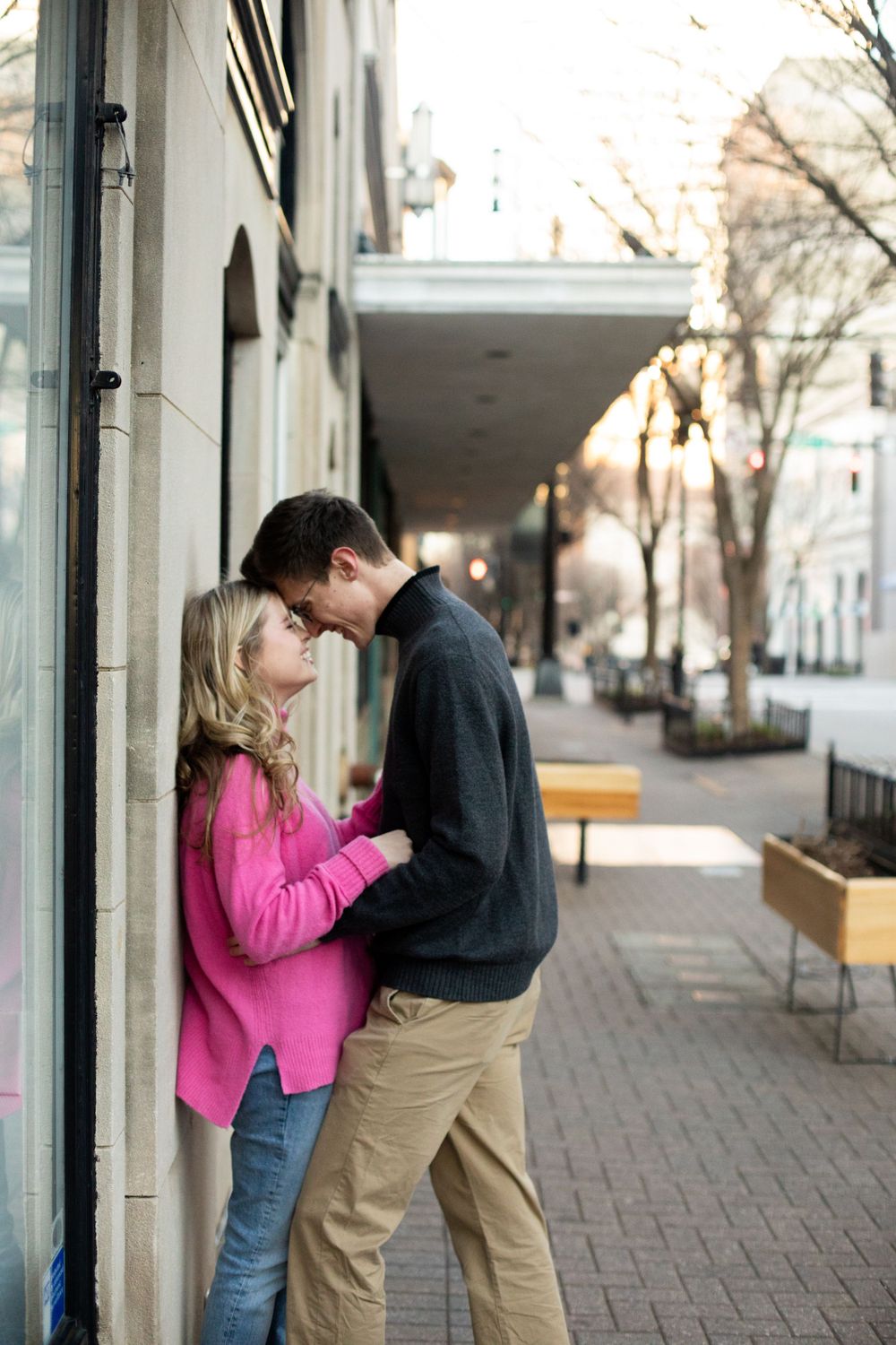 Romantic sequence of couple embracing outside urban storefront on brick sidewalk.