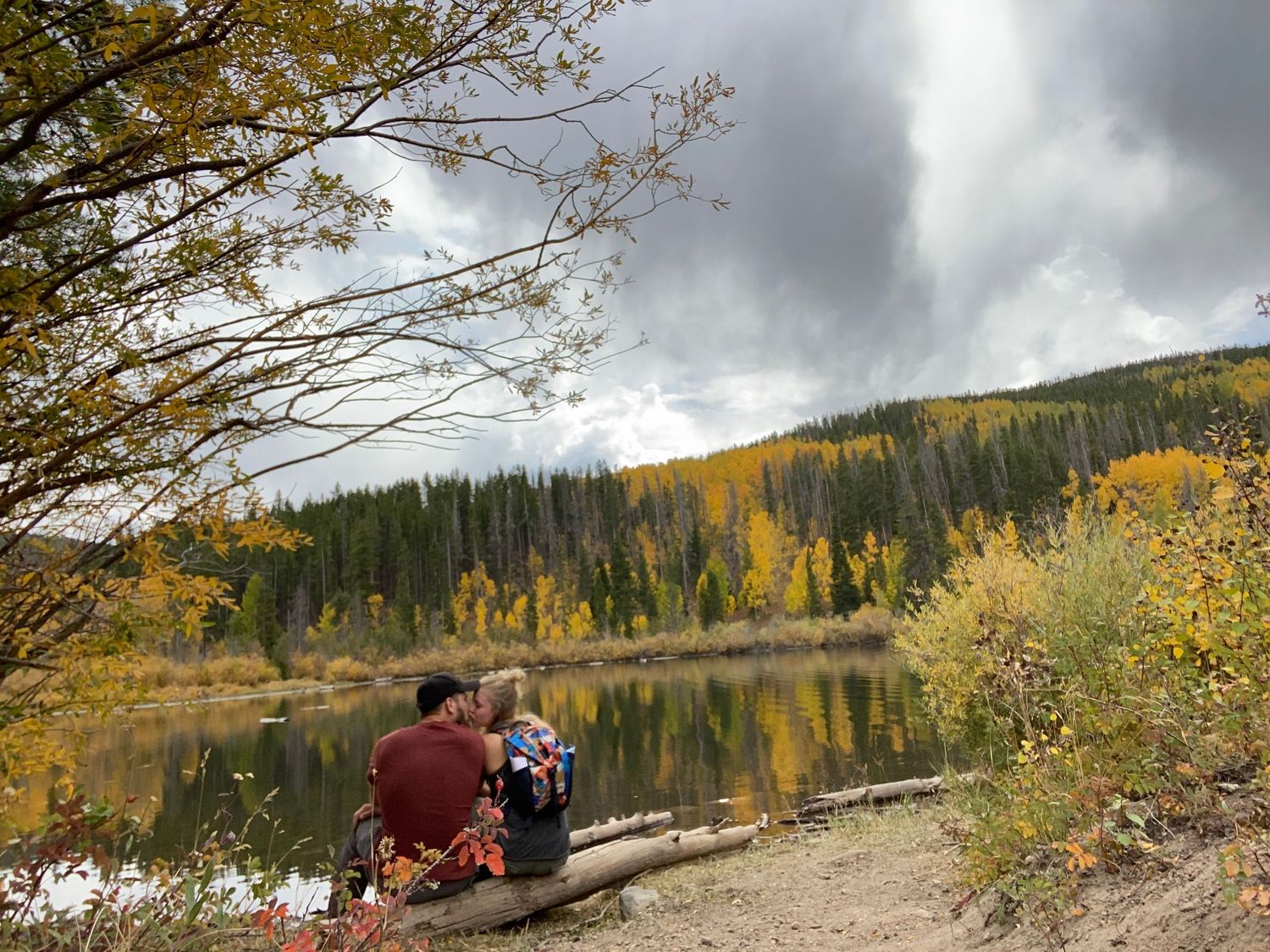Scenic mountain landscape with fall colors and dramatic cloudy sky.