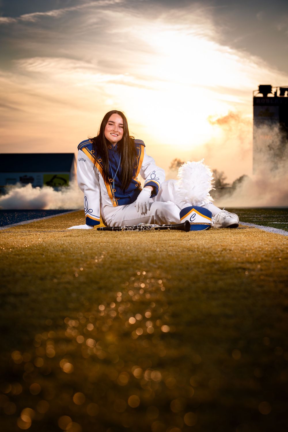 A high school band member on the field at sunset as the golden light casts a dramatic glow.