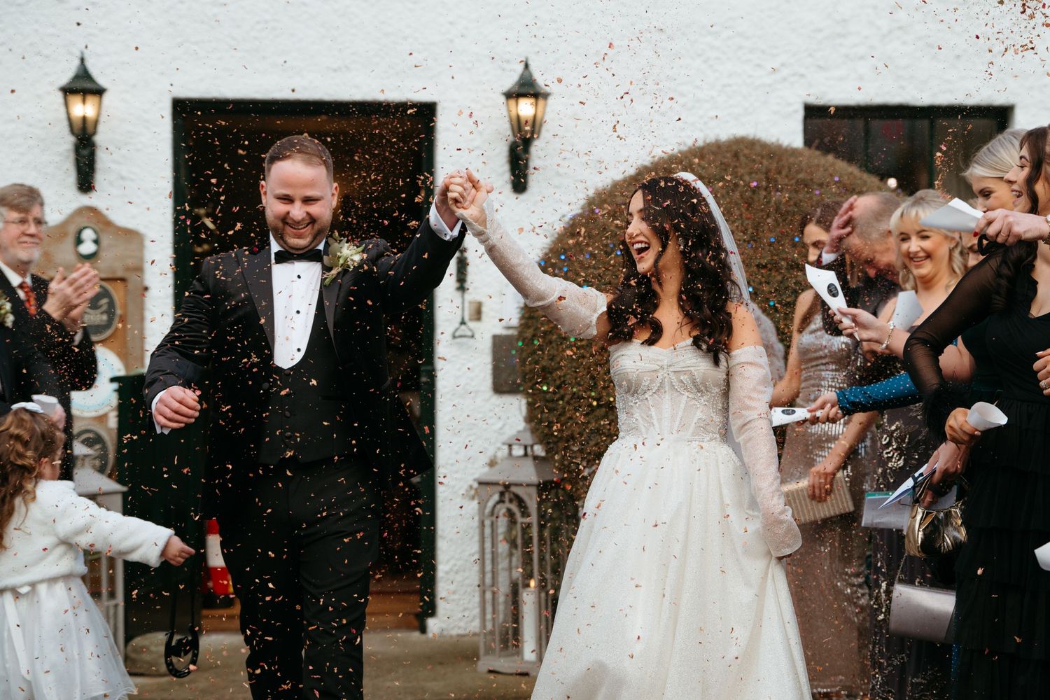 Wedding celebration moments captured in the snow with guests throwing confetti.