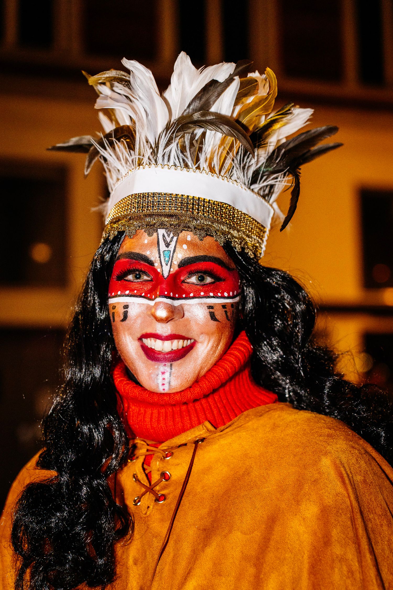 Portrait of a woman in full carnival costume, face paint, and feathered headdress at the Venlo Carnival. Vivitu photo Vastelaovend in Venlo