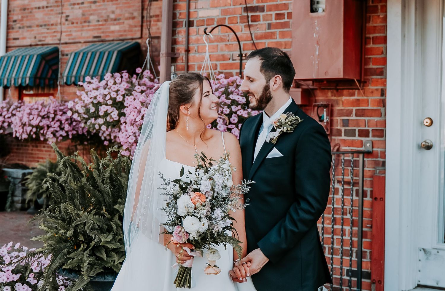 A three-part wedding photo collage featuring brick walls, pink cherry blossoms, and floral bouquets.