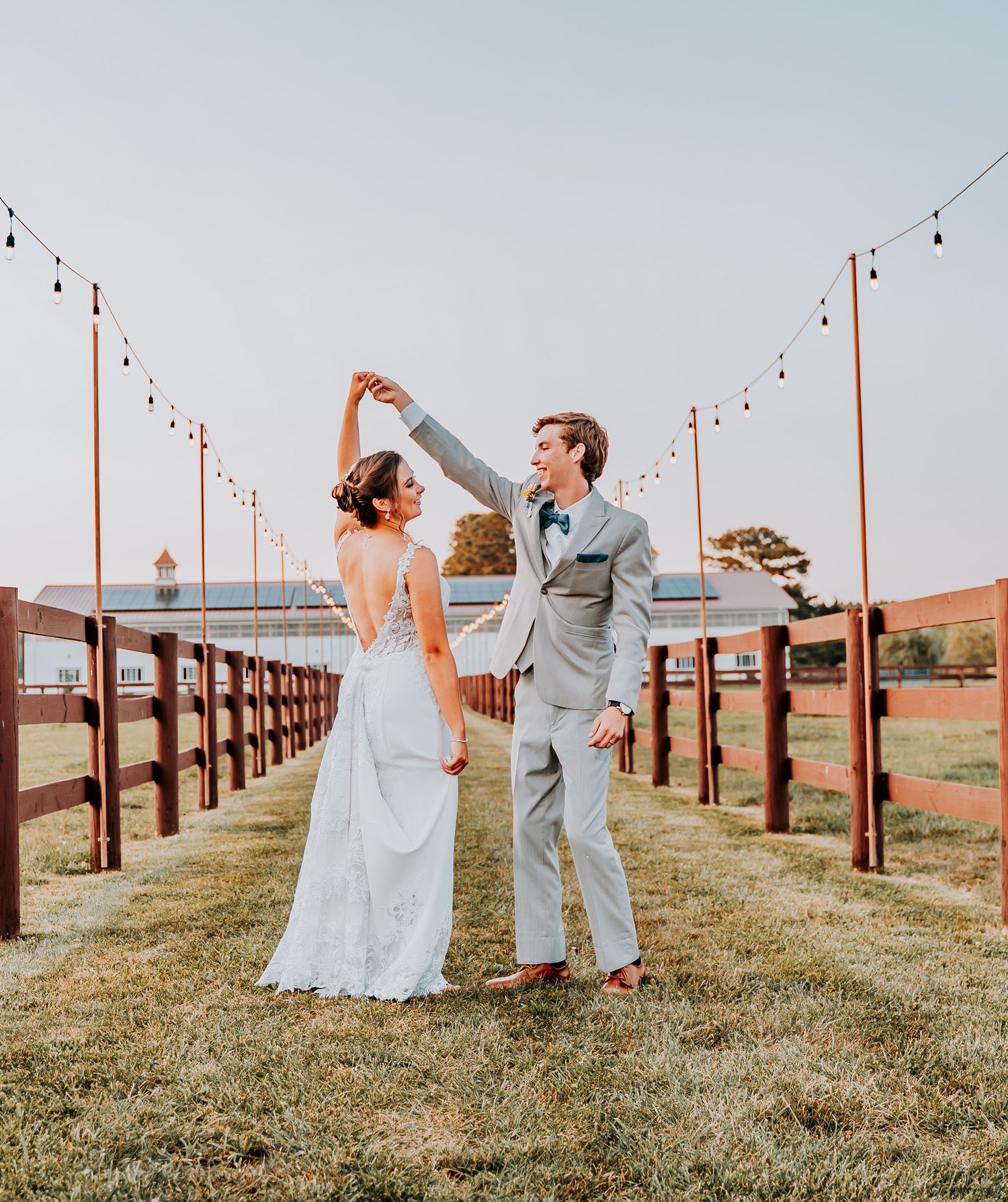 Panoramic collage showing a couple in wedding attire dancing together on a grassy hill lined with string lights at sunset.