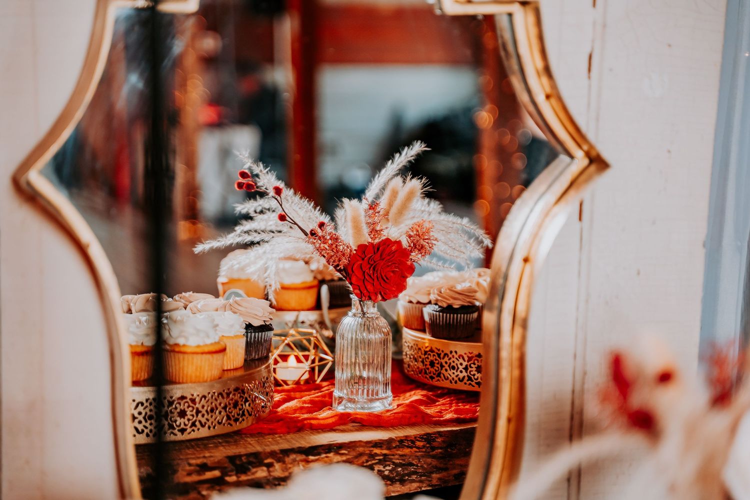 Elegant vintage mirror and ornate decor pieces create a romantic wedding reception atmosphere with warm lighting.