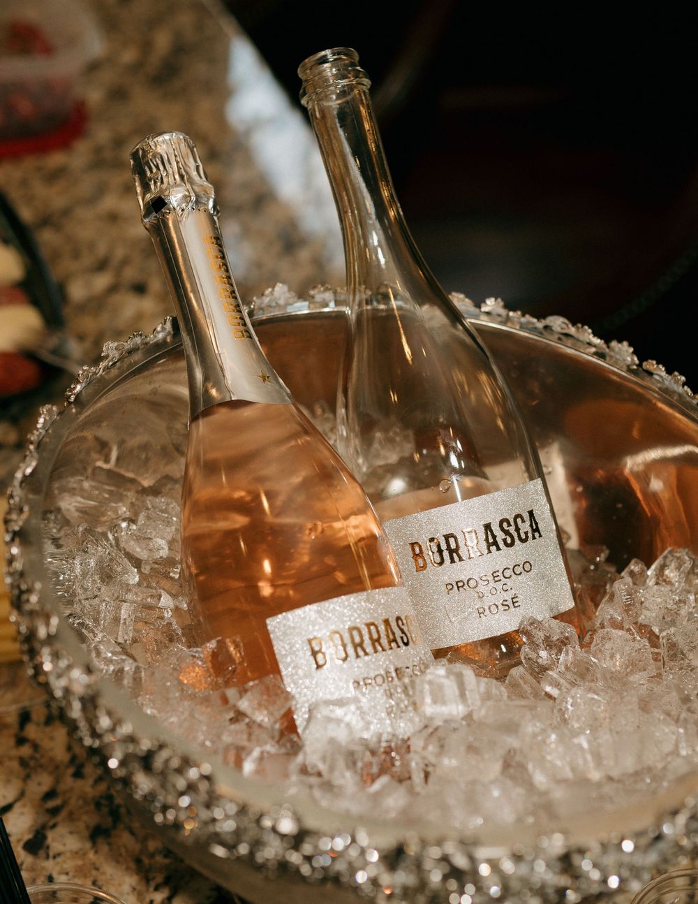 Two bottles of wine chilling in an ice bucket at a wedding reception.