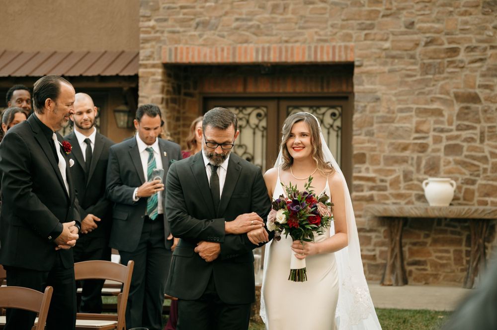 A joyful wedding ceremony moment captured outside a stone building.