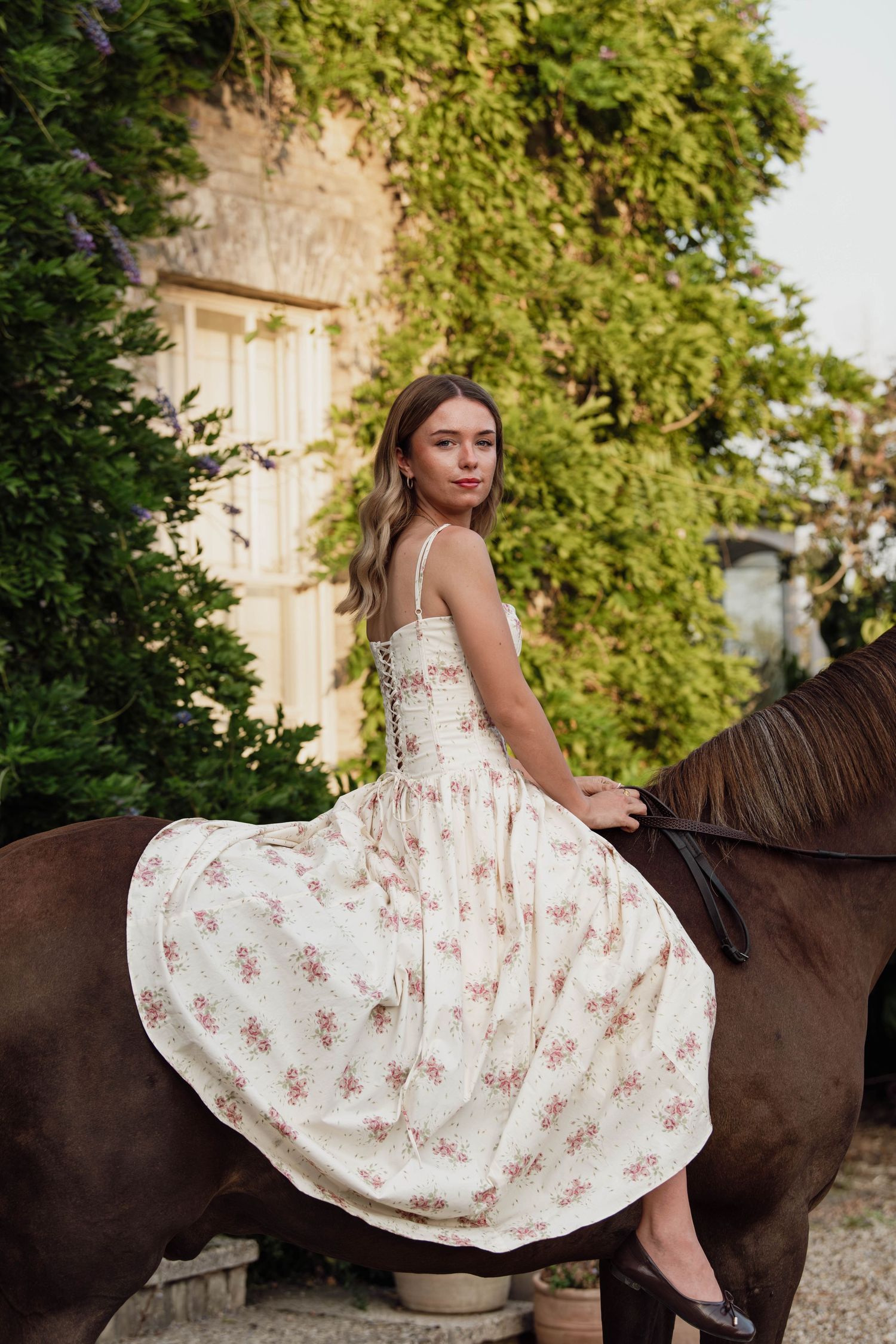 Black horse adorned with colorful competition rosettes and ribbons standing in an autumn woodland setting.