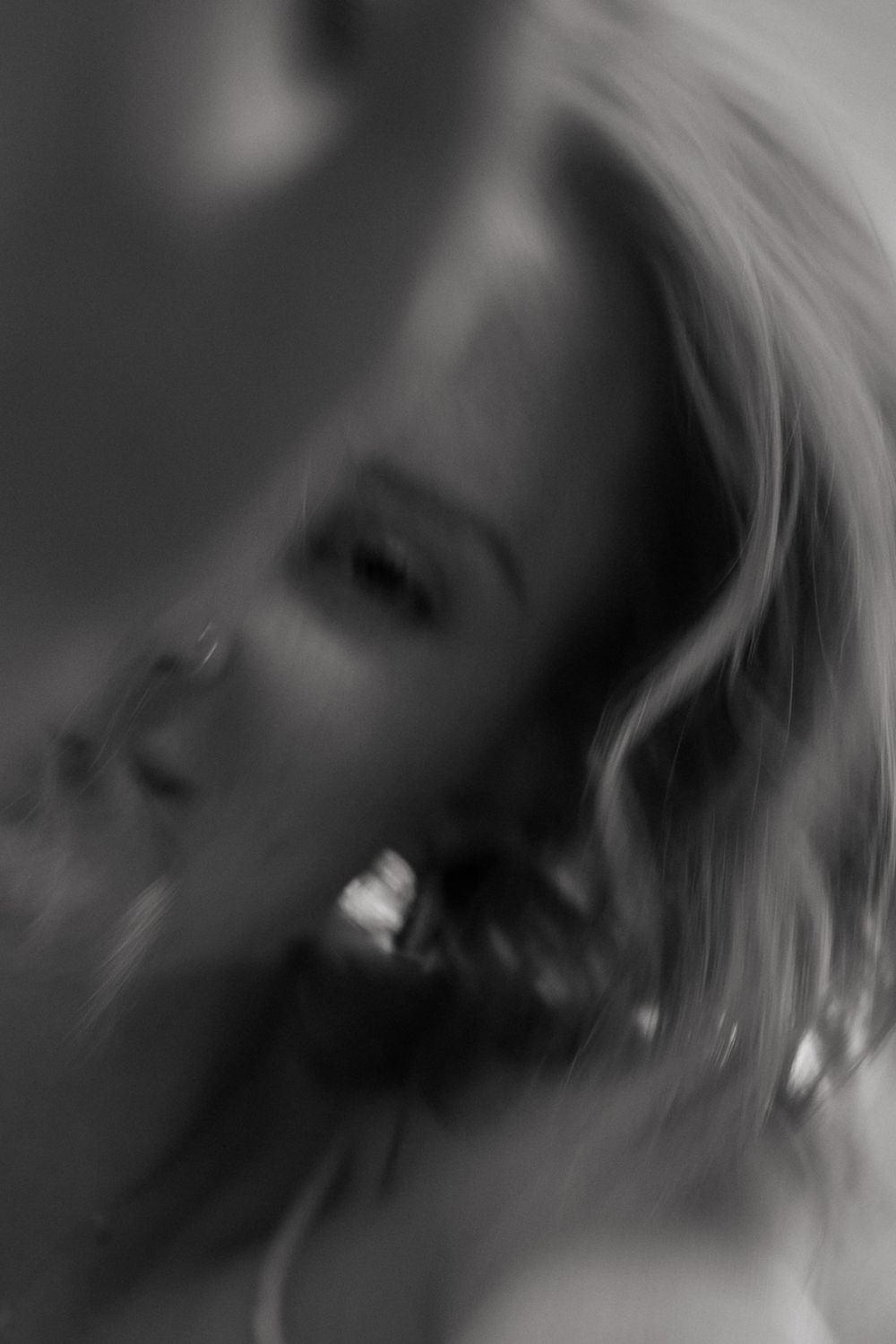 Black-and-white close-up of a slightly blurry woman during a creative portrait photo session in Fort Worth, Texas.