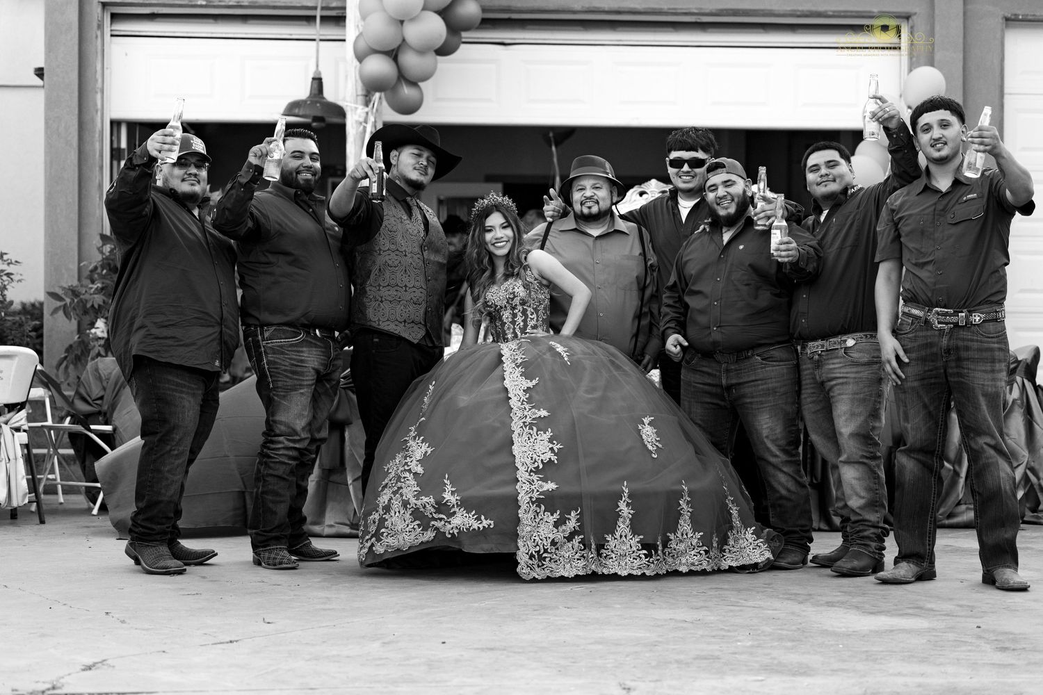 Black and white group photo with celebratory poses and balloons in background.