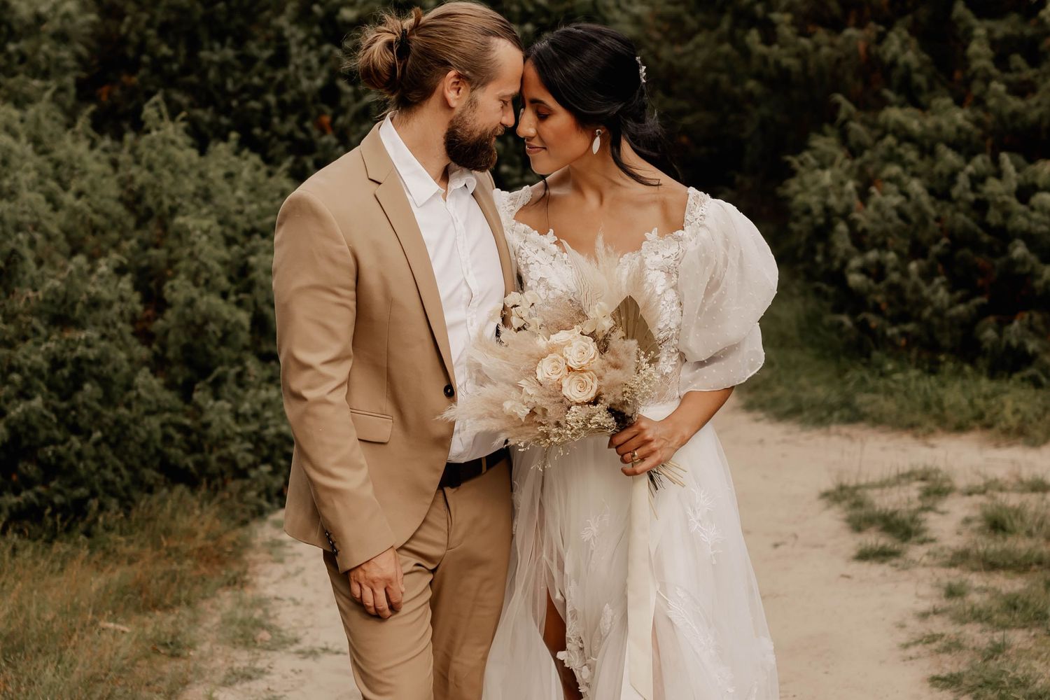 An intimate wedding portrait of a couple with neutral tones in a natural outdoor setting.