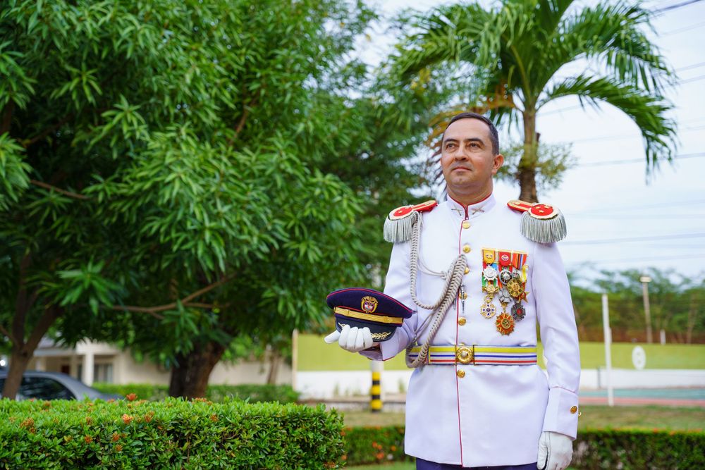 Pareja de novios, Lina y Nestor, avanzando juntos bajo un arco de espadas en su elegante ceremonia de boda en la Catedra