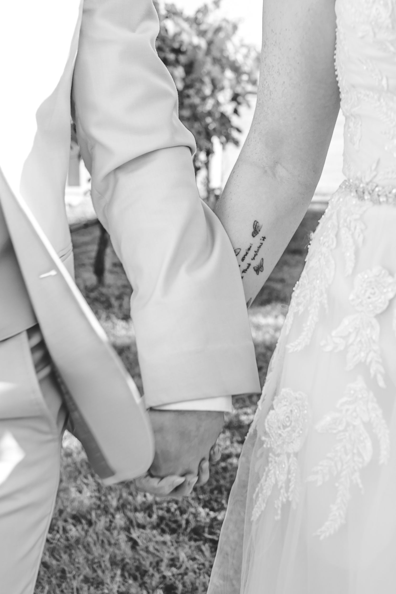 Black and white detail shot of bride and groom's legs showing wedding attire.