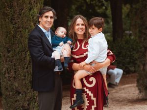 Family portrait in front of garden hedge wearing formal attire.