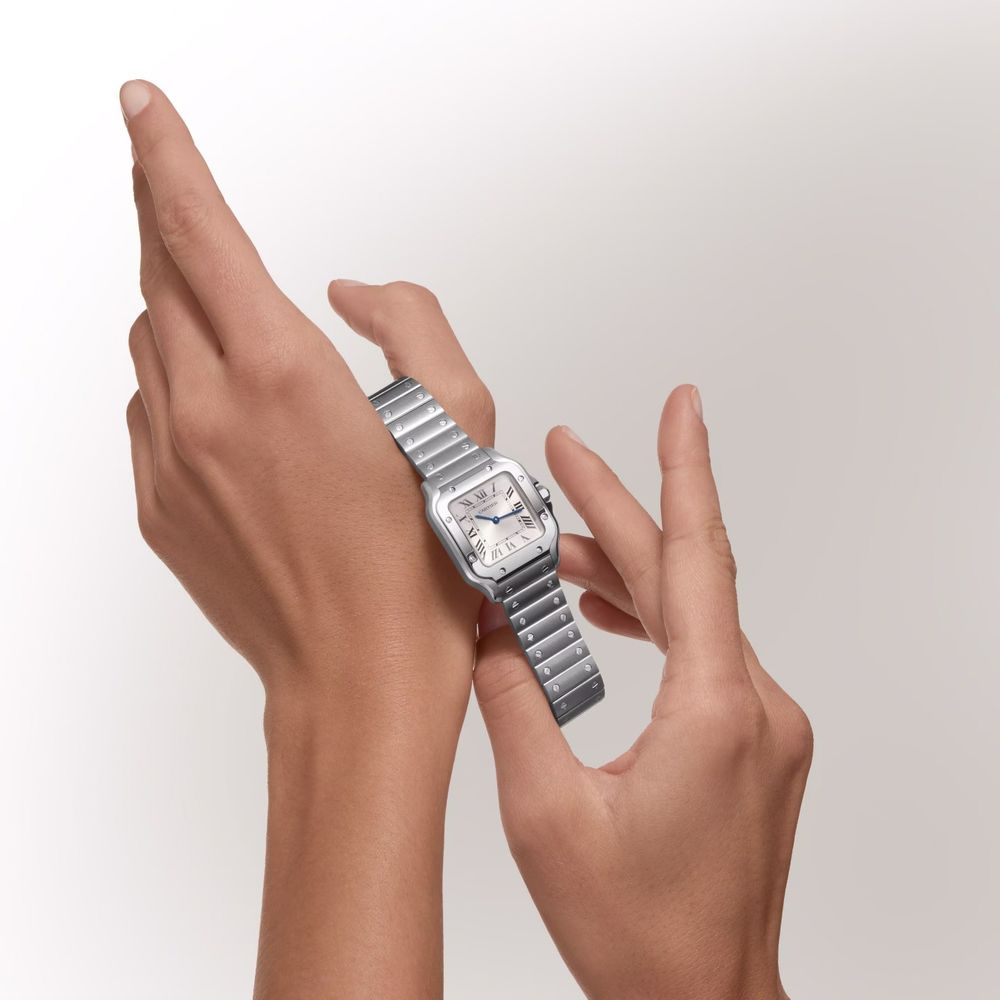 Hand holding a silver ring with a textured metal band and a large square crystal centerpiece against a white background.