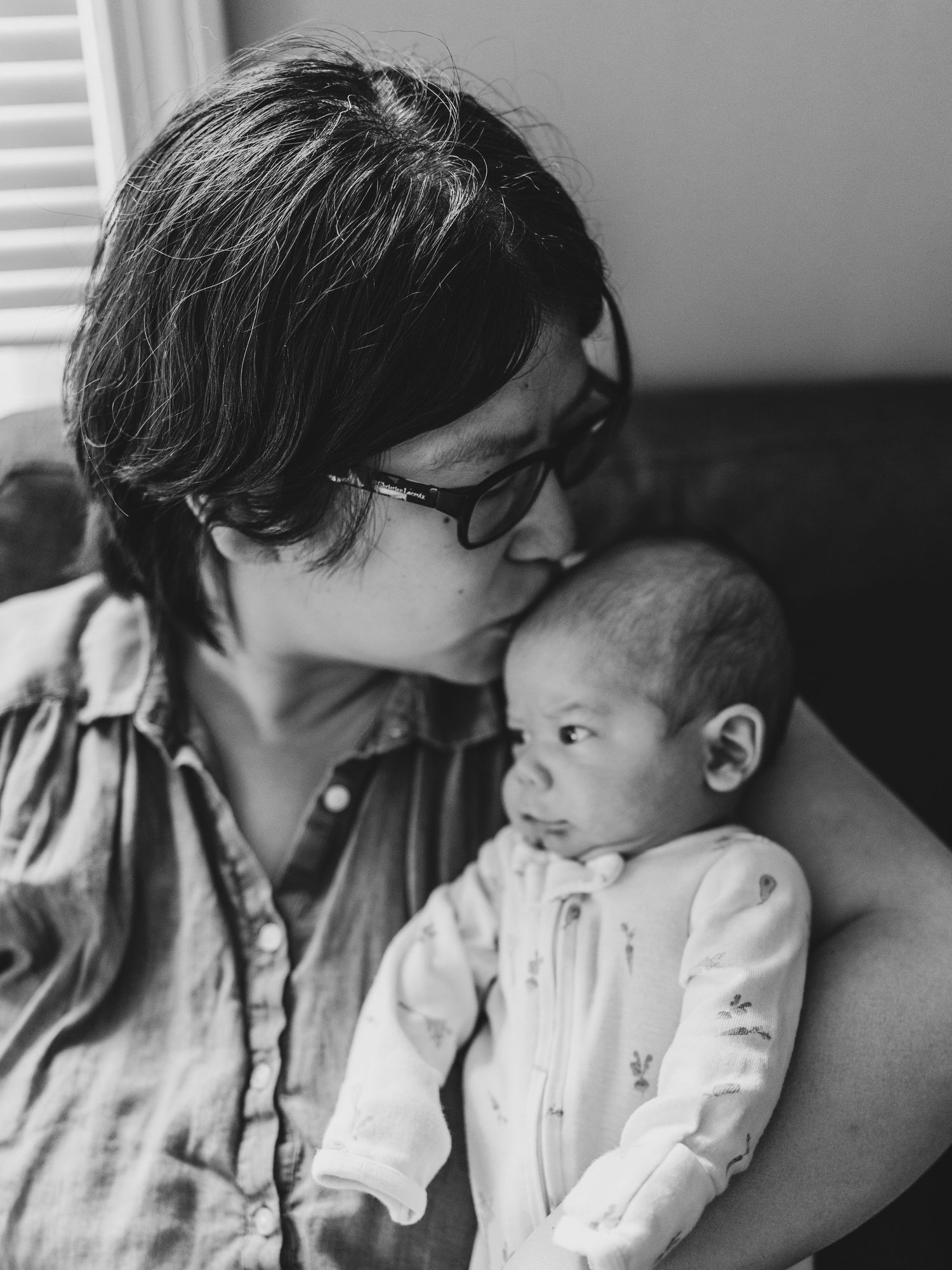 Intimate black and white portraits showing tender moments with newborn baby.