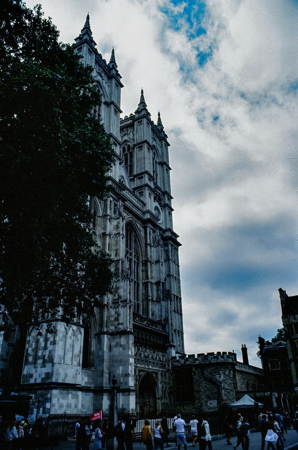 Gothic spires of Westminster Abbey reaching toward cloudy London sky.