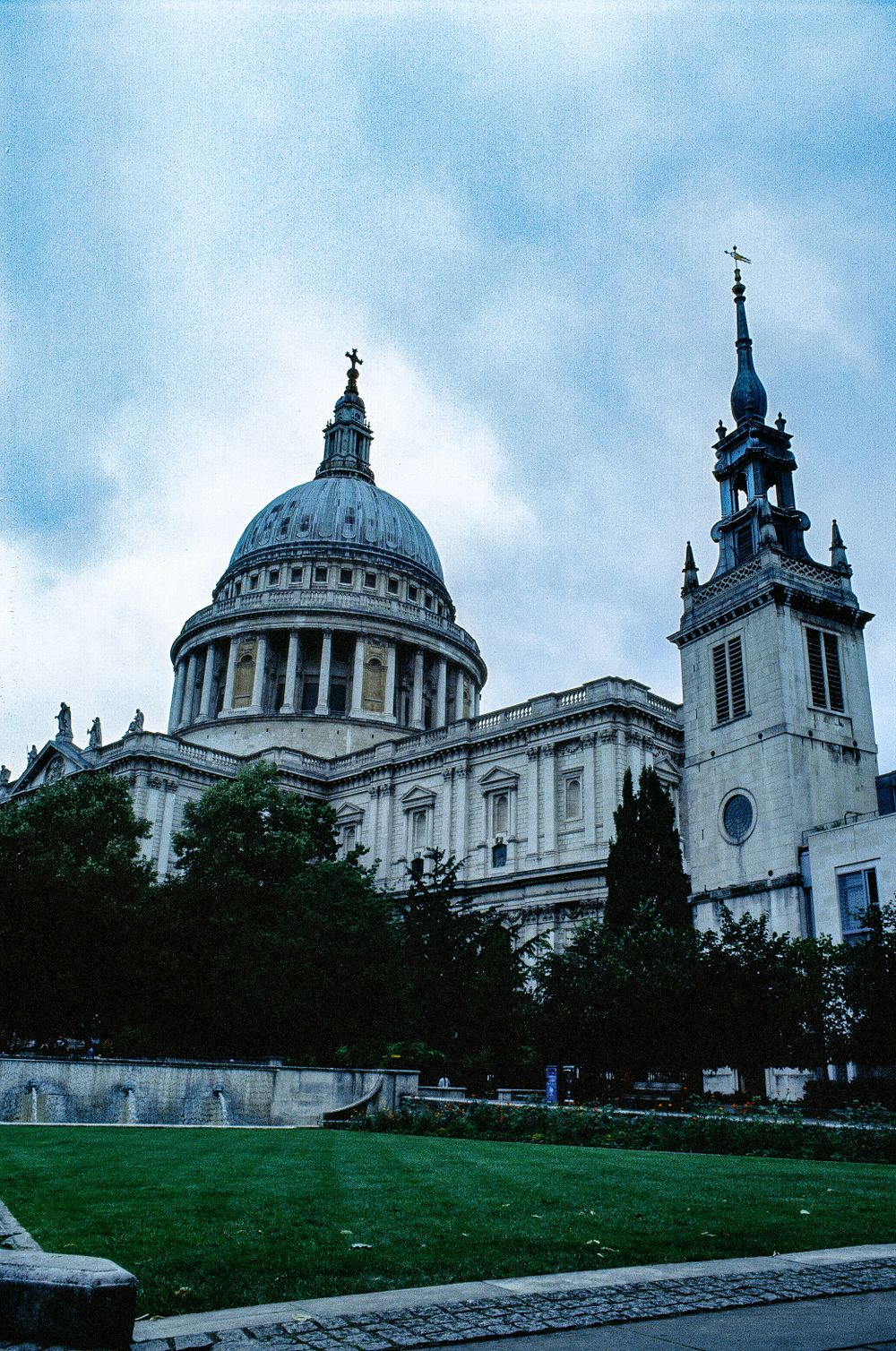 St Paul's Cathedral dome and spire against cloudy sky in London.