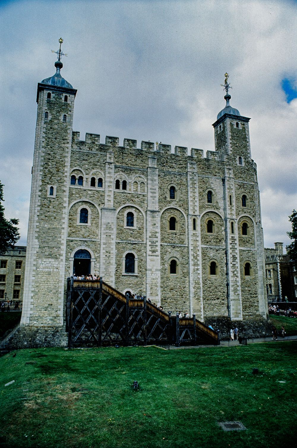 White Tower at Tower of London with wooden scaffolding against cloudy sky.