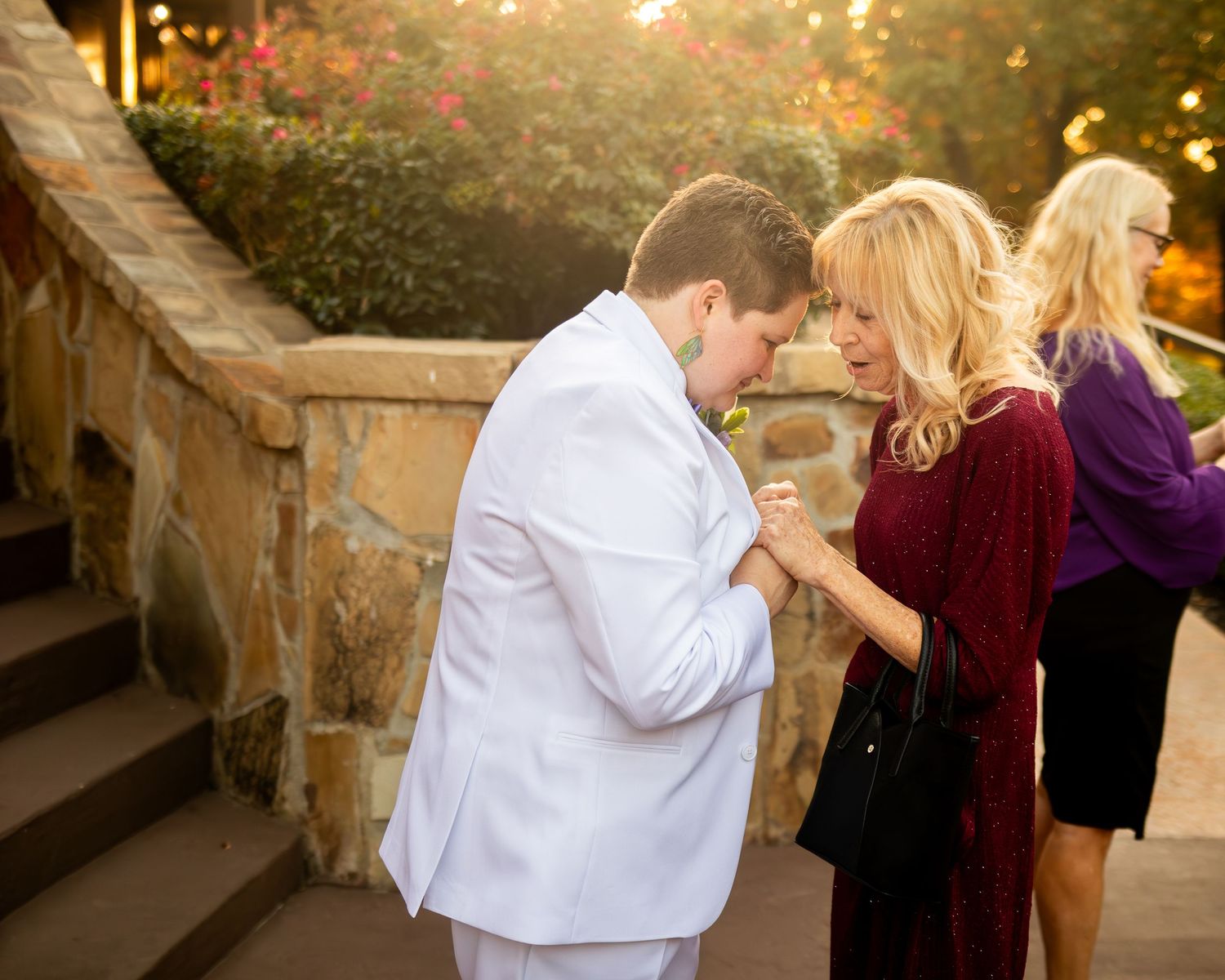 Loving moment captured on stone steps during golden hour.