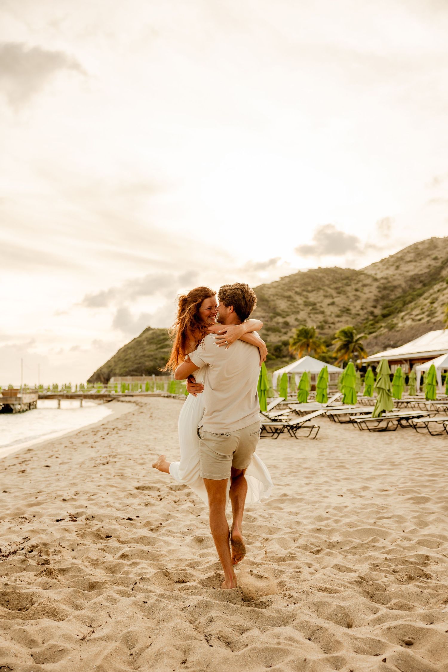 Couple dancing on the beach at sunset looking at each other
