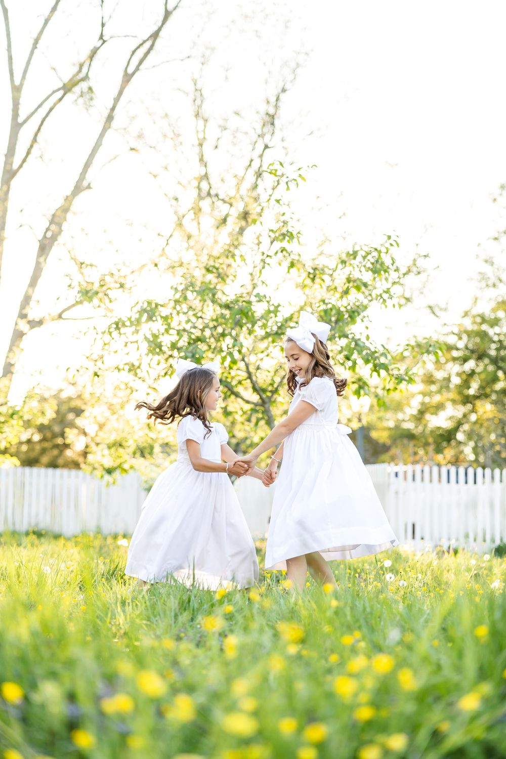 Light and airy photography of children dancing in buttercups in Colonial Williamsburg in Virginia.