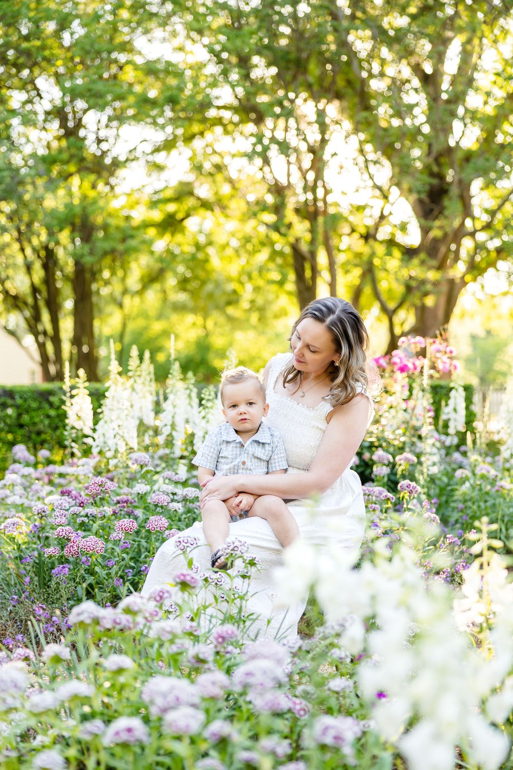 Photography of Mom and baby embracing in flower garden in Colonial Williamsburg.
