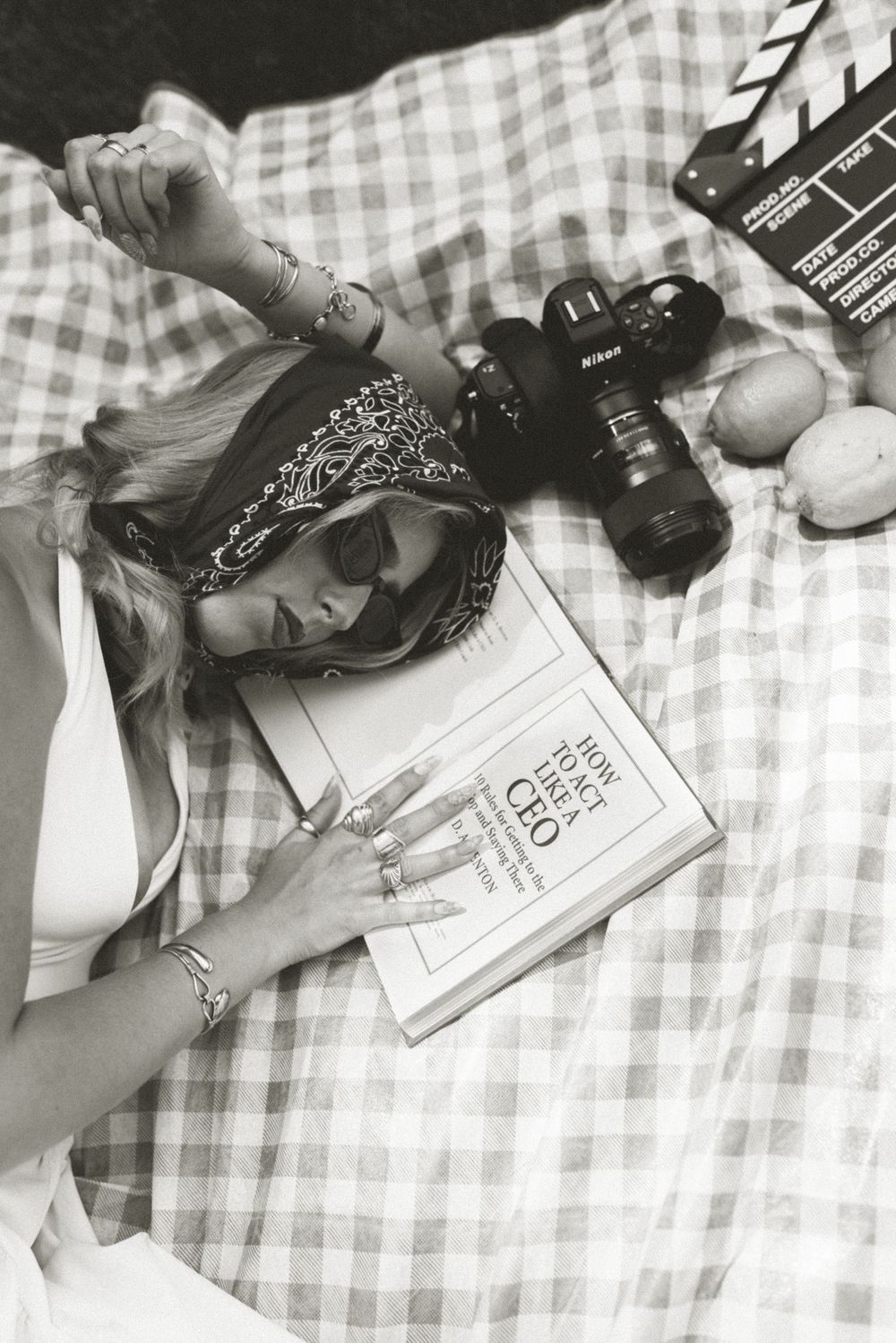 Portrait of someone holding a vintage camera while wearing a denim dress and fuzzy white sweater.