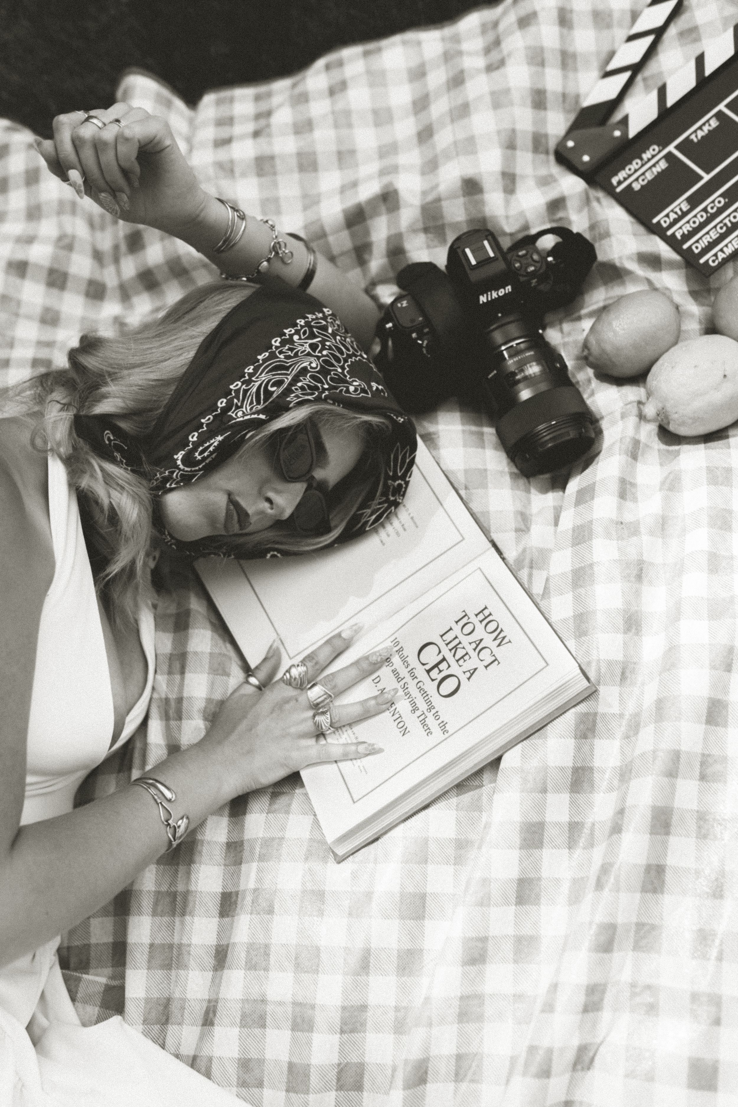 Portrait of someone holding a vintage camera while wearing a denim dress and fuzzy white sweater.