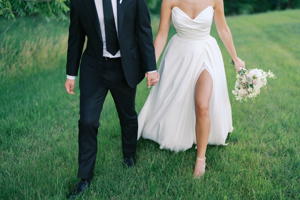 Classic and film-inspired wedding photography in Madison, Wisconsin. Bride and Groom walking outdoors at The Eloise Mount Horeb.