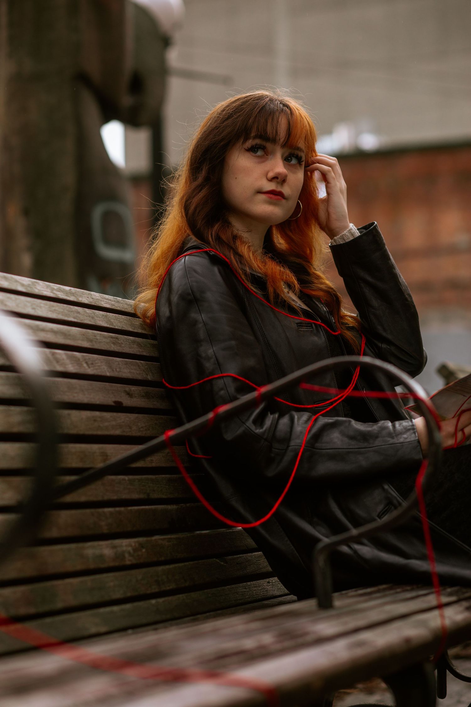 woman sitting on bench in pioneer square seattle red hair leather jacket
