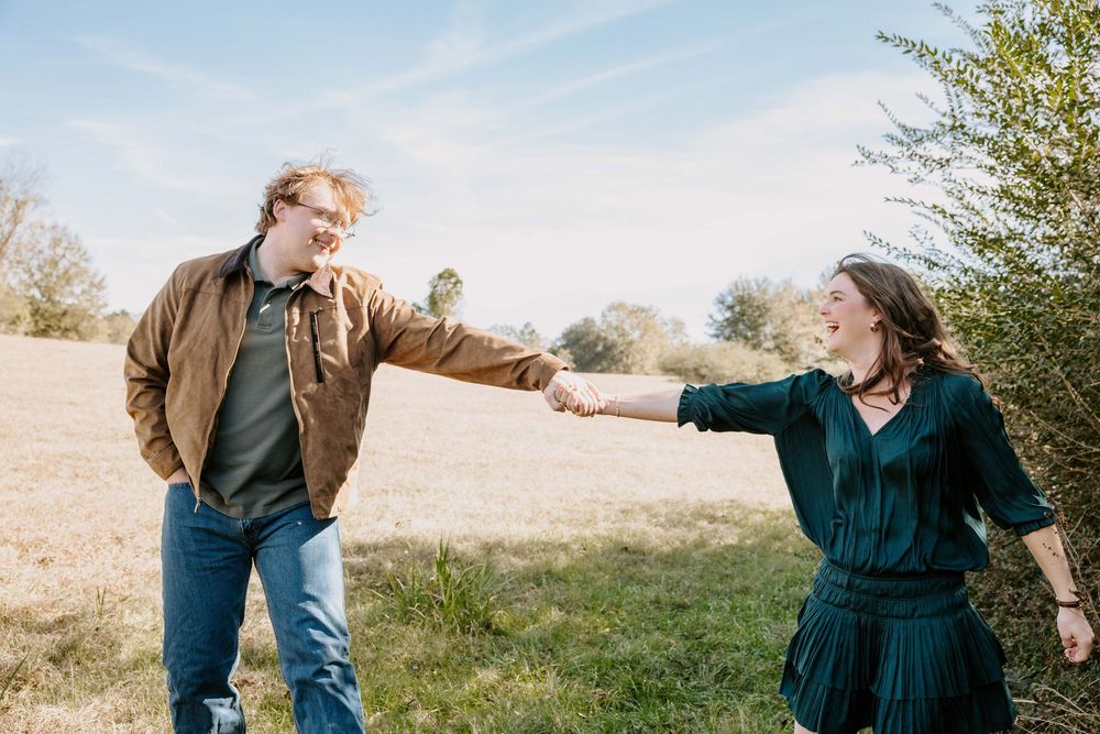 Couple shares playful and candid moments together outdoors during a photo session.