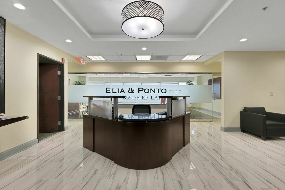 Professional office reception desk for Elia and Ponto LLC with marble flooring and elegant lighting.
