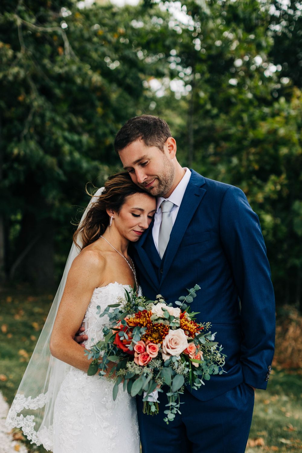 Intimate wedding moment captured in garden setting with stunning fall florals.
