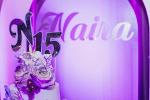 Purple-lit quinceanera cake decoration featuring N15 and floral accents.