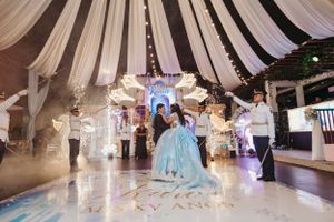 Elegant celebration setup with draped white fabric ceiling and illuminated dance floor.