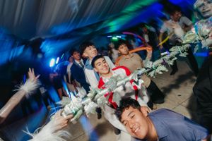 Party guests strike dynamic poses on the dance floor under blue mood lighting at a celebration.