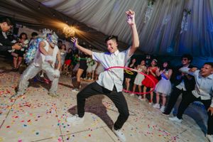 A dancer performs an energetic move on a confetti-covered dance floor during a celebration.