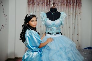 A blue quinceañera dress displayed on a mannequin with matching robe.