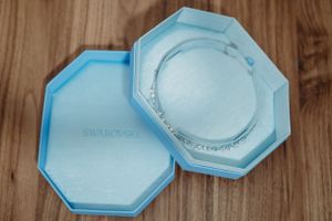 Light blue hexagonal jewelry box displayed on wooden surface.