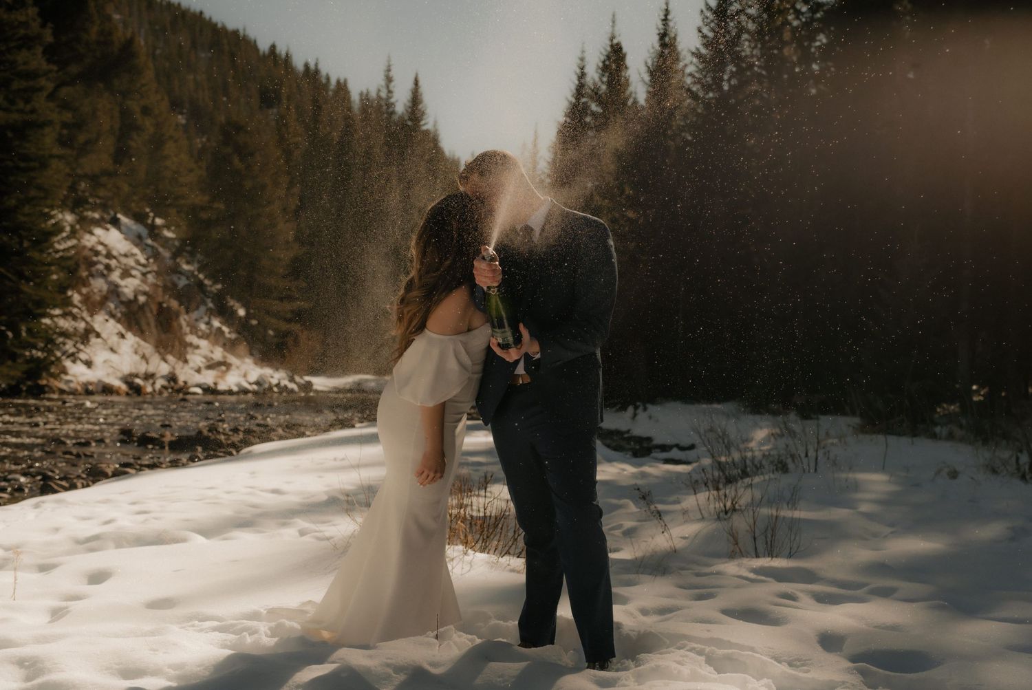 Winter wedding photo with snowy pine forest backdrop.