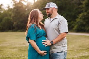 Couple shares intimate moment during outdoor sunset photo session.